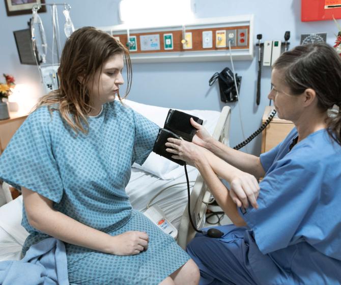 a nurse puts a blood pressure cuff on a woman