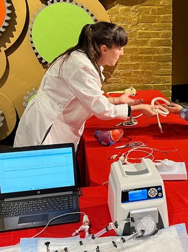 A photo of Dr. Gretel Monreal show equipment to a HeartWheels! attendee